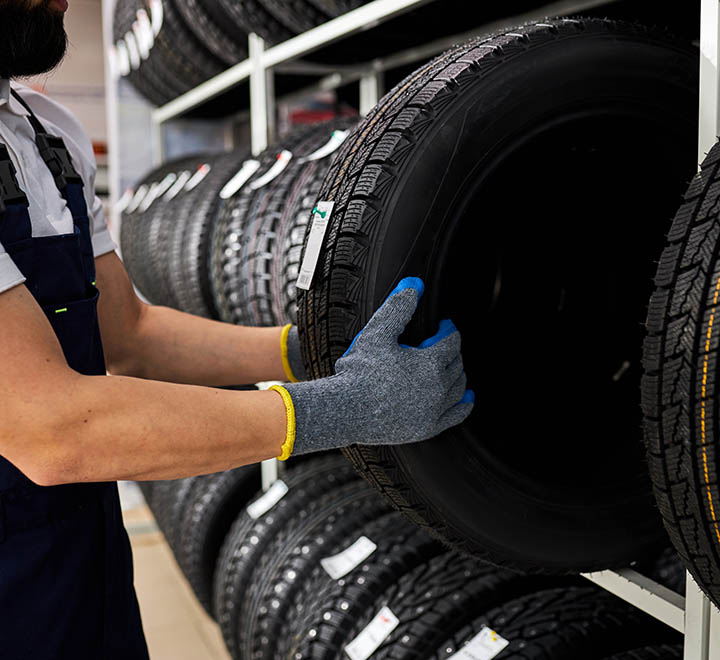 retirement man touching and choosing for buying a tire, measuring rubber car wheel, taking it from shelf with assortment