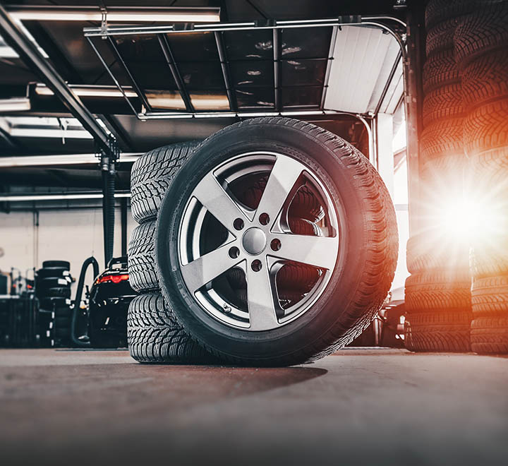 tire at repairing service garage background. Technician man replacing winter and summer tyre for safety road trip. Transportation and automotive maintenance concept