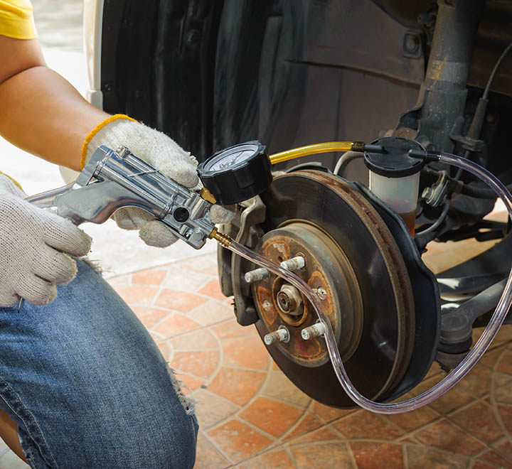 Car mechanic bleed air out of brake system