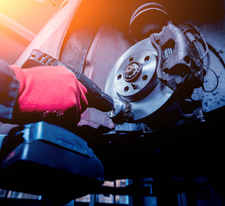 Cleaning disc brake on car, in process of new tire replacement. Car brake repairing in garage